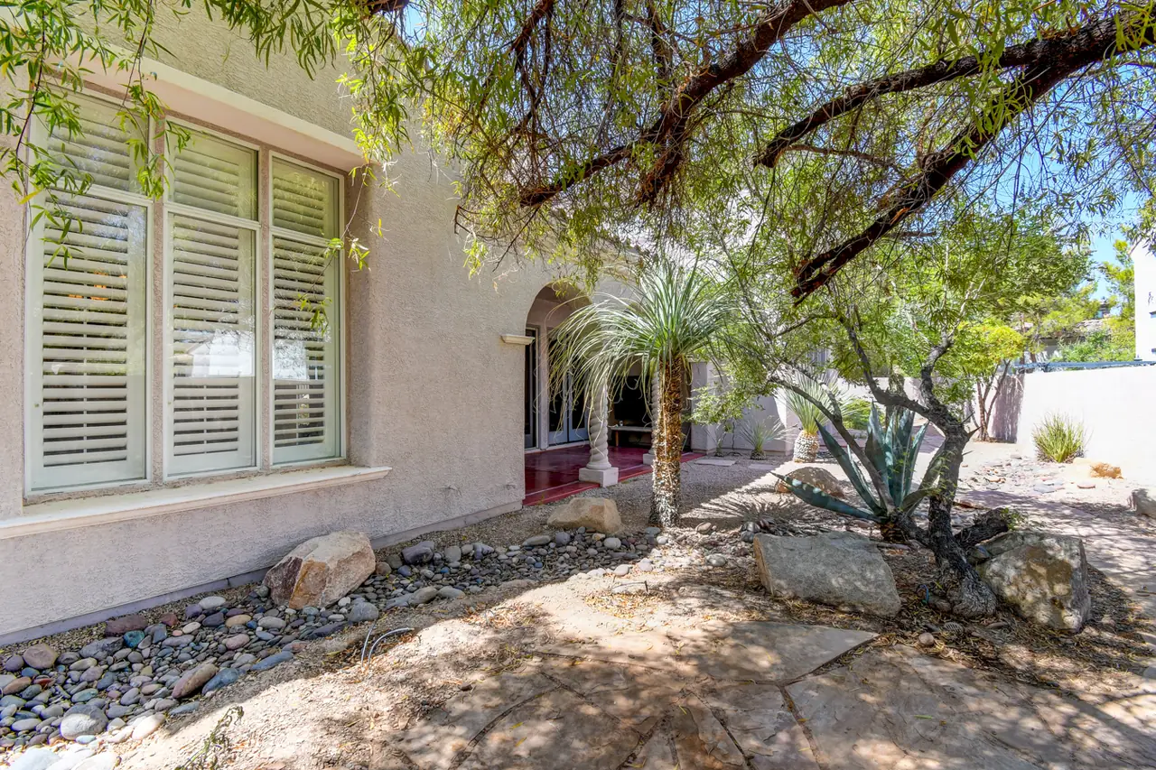 Back of the house with shuttered windows and shade trees