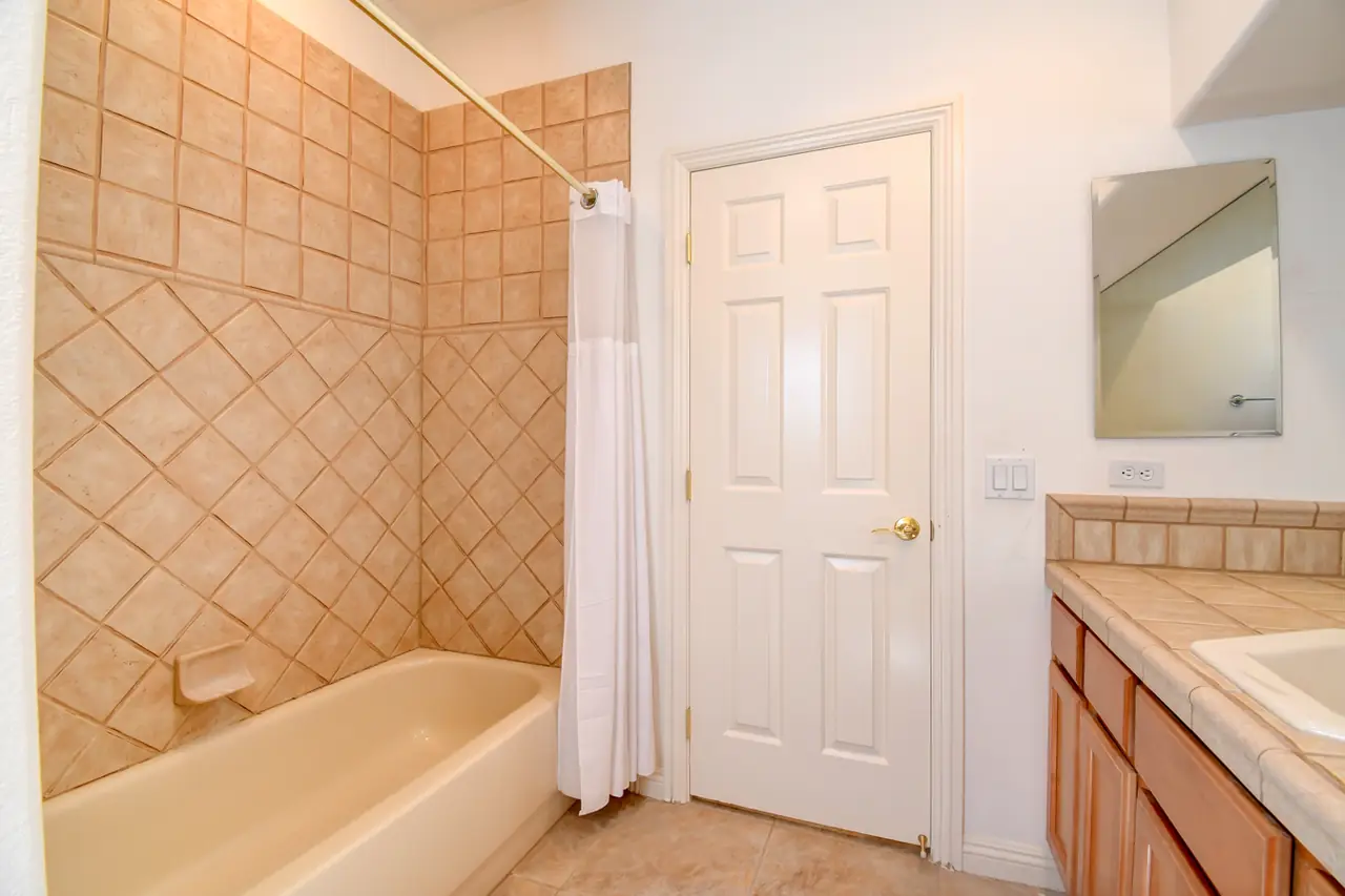 Bathroom with tiled tub and shower combination