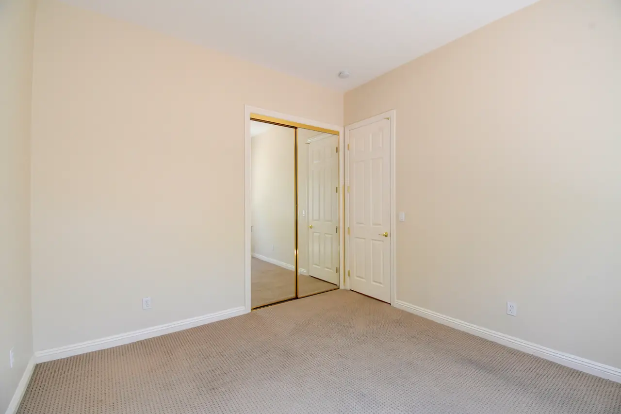 Secondary bedroom with mirrored closet doors