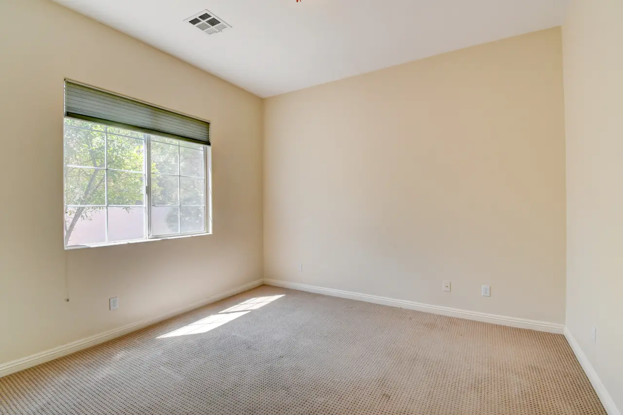 Secondary bedroom with carpet and a large window