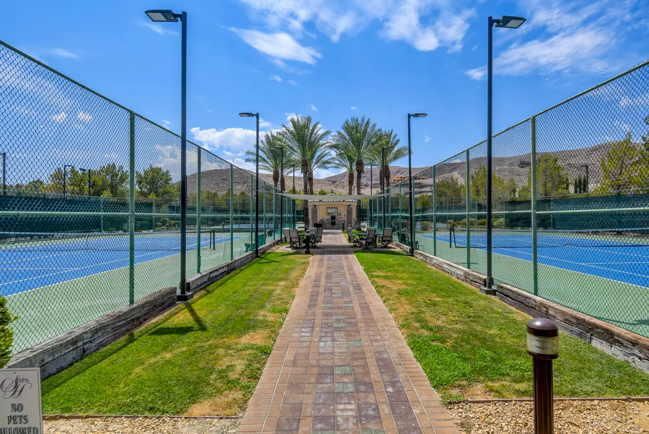 Community tennis courts with a palm-lined walkway