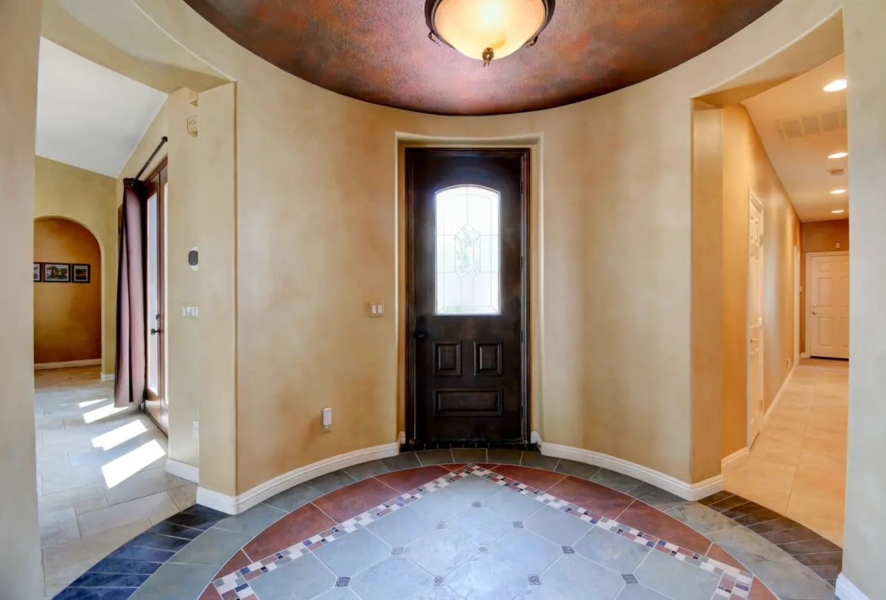 Foyer with decorative tile inlay and arched front door