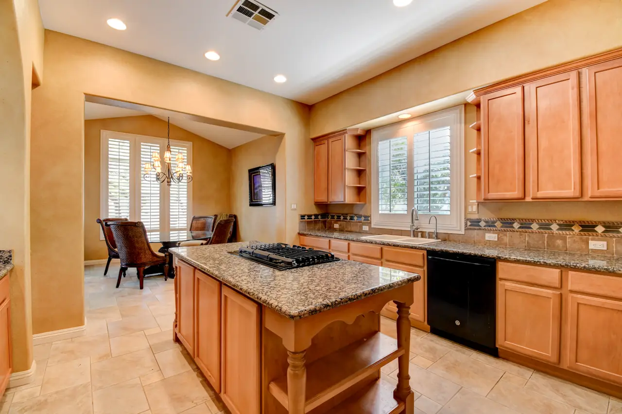 Kitchen island and counters opening to the breakfast nook with plantation shutters