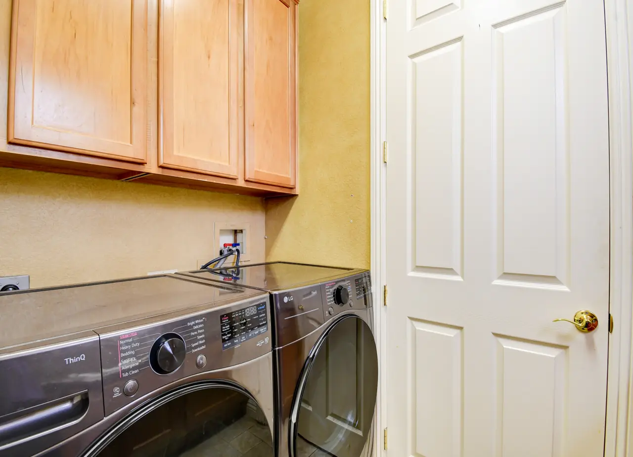 Laundry room with washer, dryer and overhead cabinets
