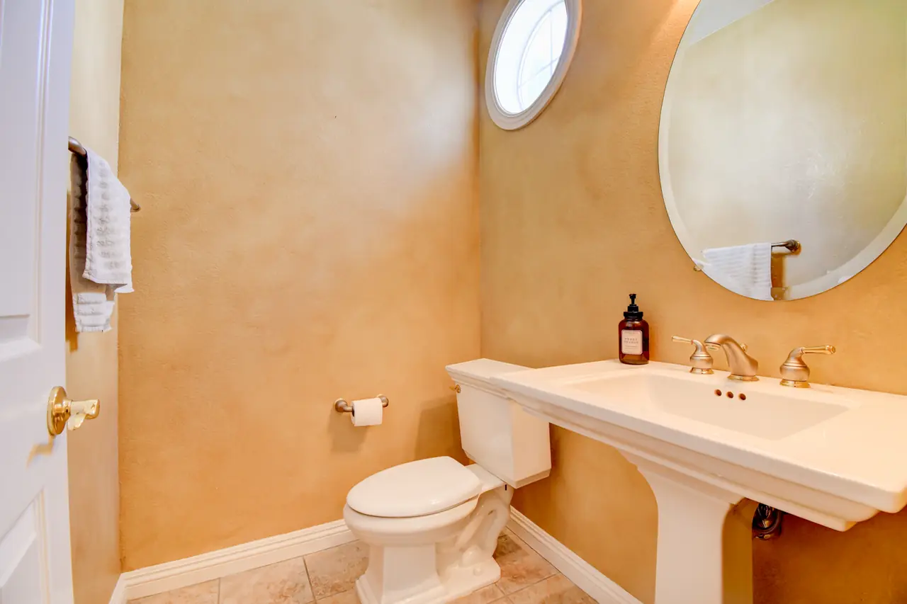 Powder room with pedestal sink and oval window