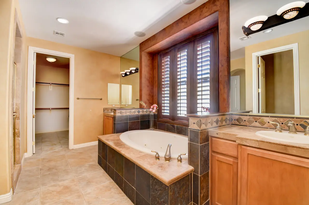 Primary bath with soaking tub, dual vanities and shutters