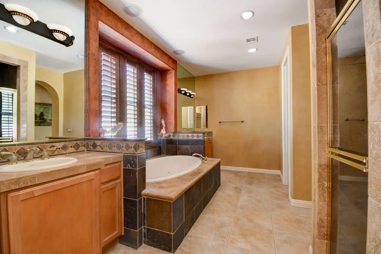 Primary bath vanity and makeup table beside the tub