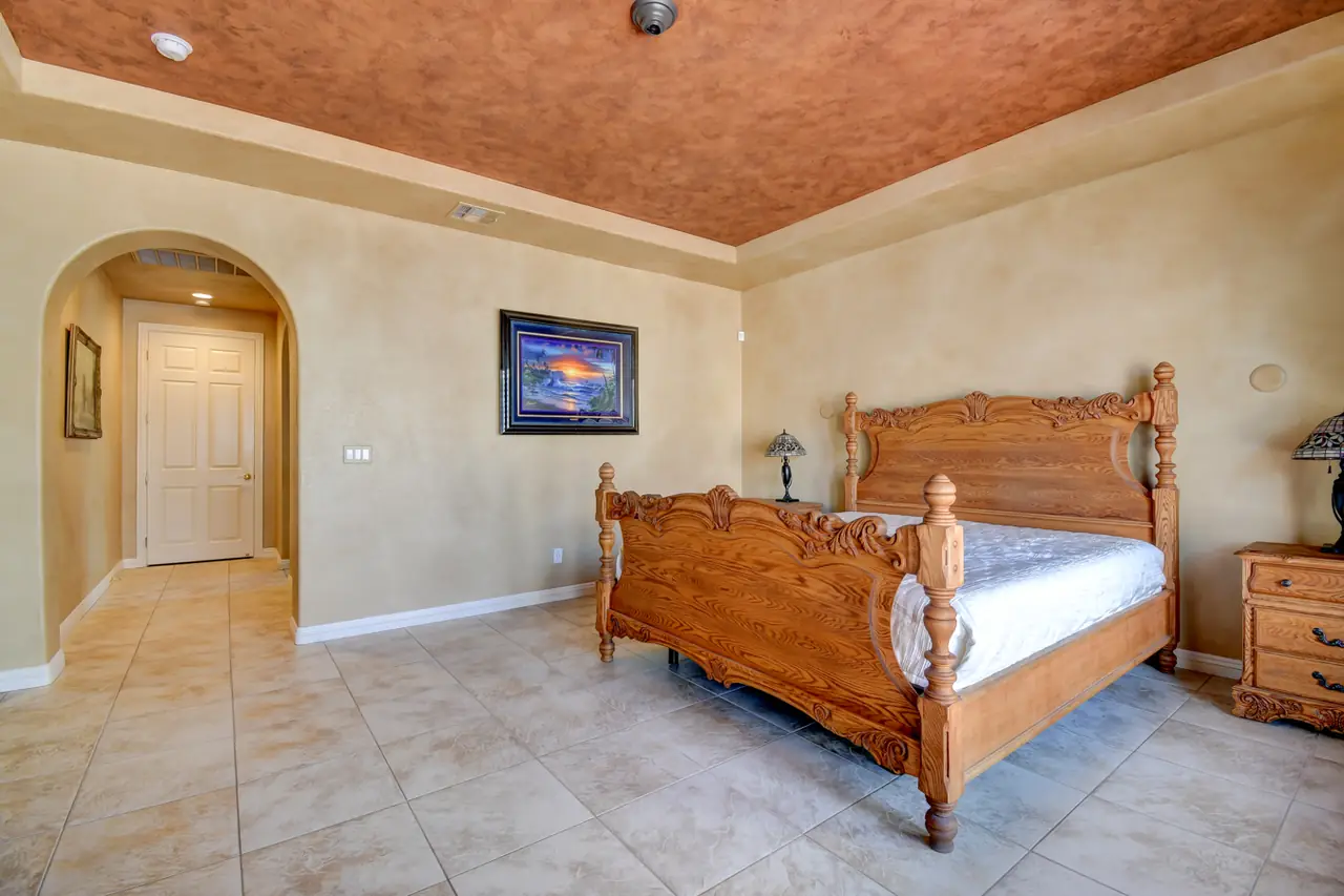 Primary bedroom with carved bed and arched doorway