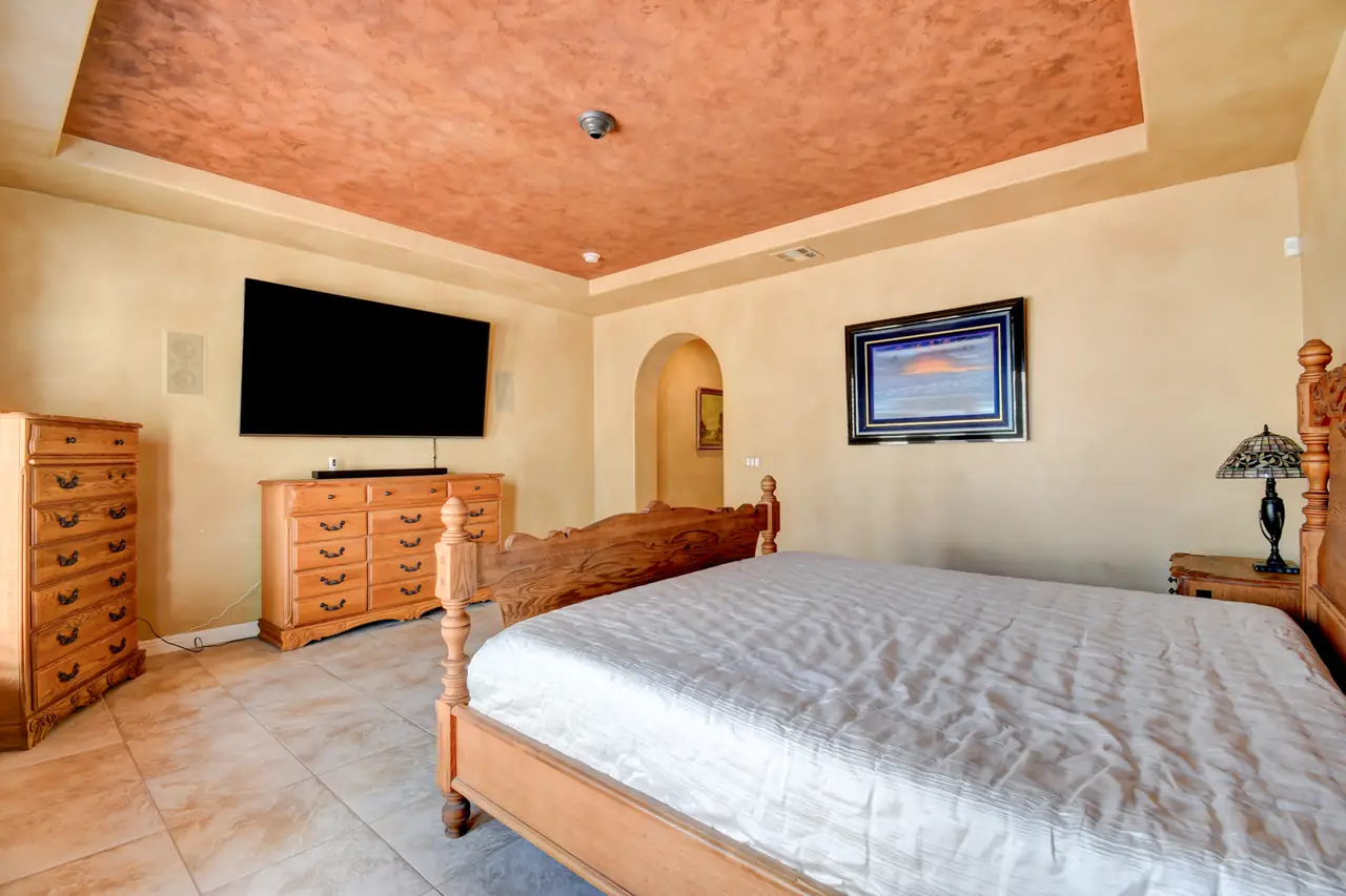 Primary bedroom sitting wall with television and dresser