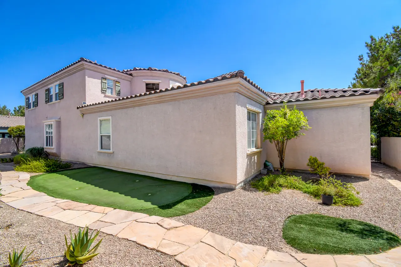 Side yard with artificial turf putting green and flagstone path