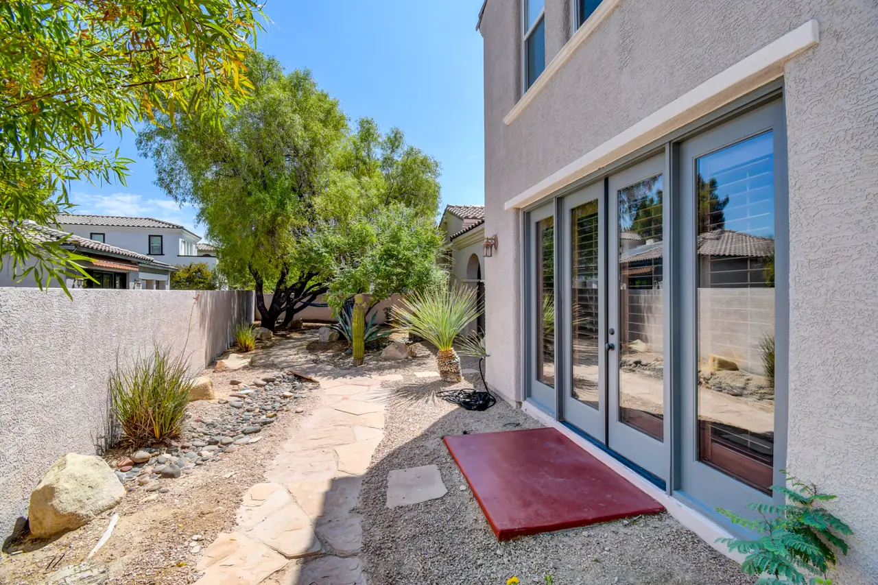 Rear patio with glass sliders and desert plantings